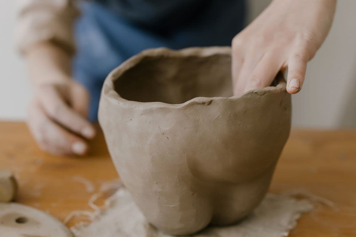 Un atelier créatif manuel : des mains façonnent un objet en argile
