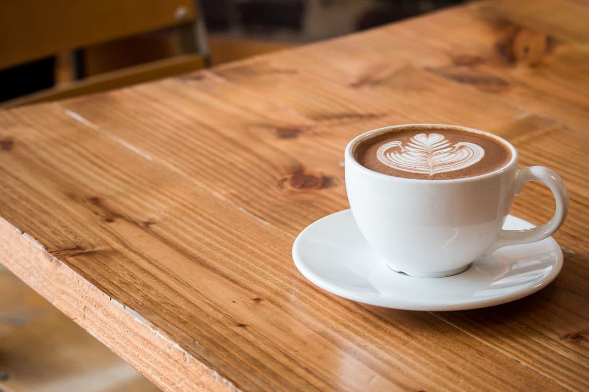 Un café de spécialité avec latte art sur une table en bois